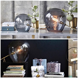Lampe à poser avec un superbe design globe en verre fumé et pied en laiton